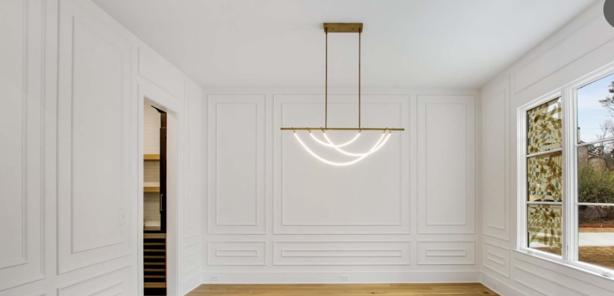 Formal room with wainscoting and statement lighting